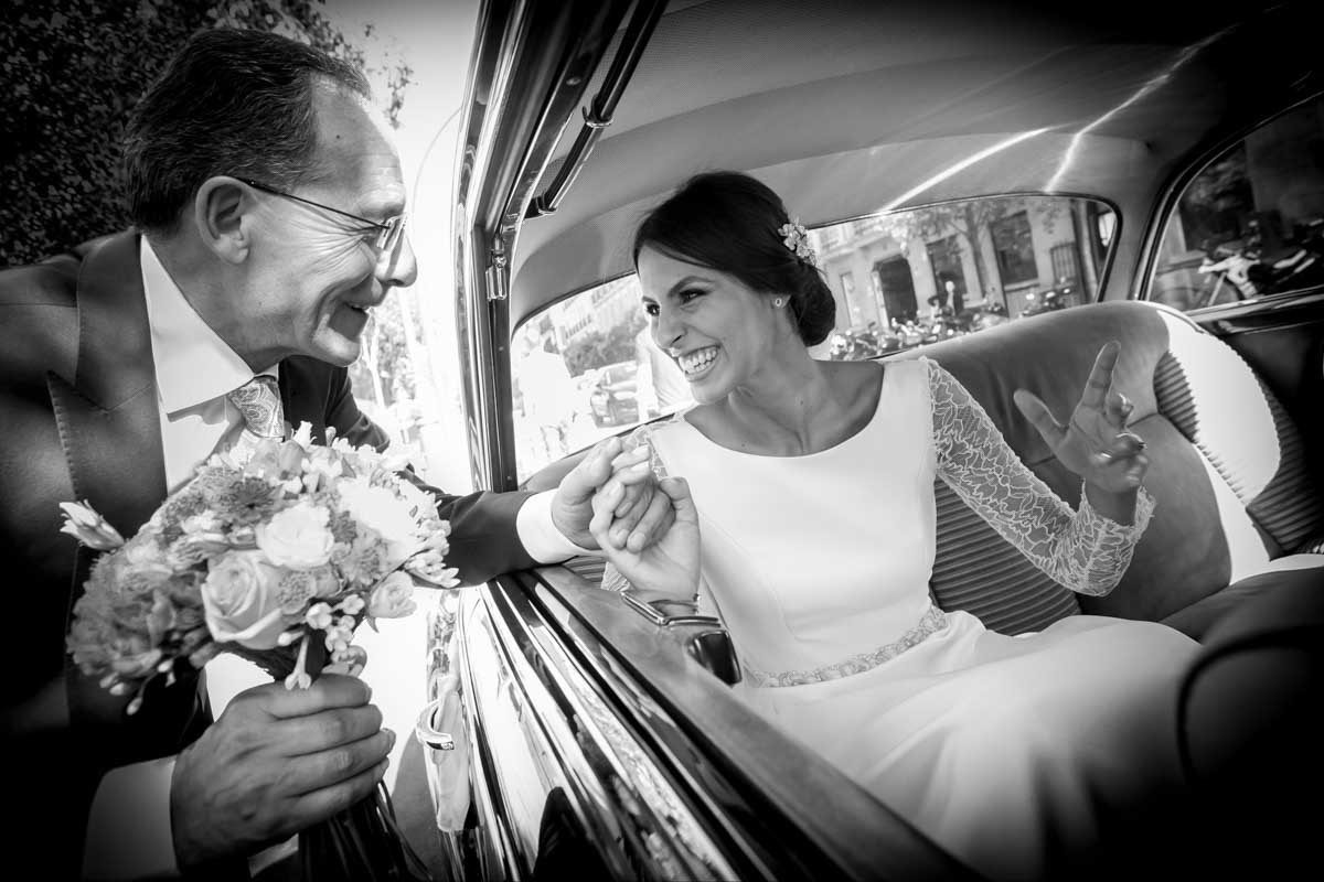 Fotografía realizada por bodas con fotos de una novia sonriendo a su padre antes de salir del coche en la puerta de la iglesia de Santa Bárbara.