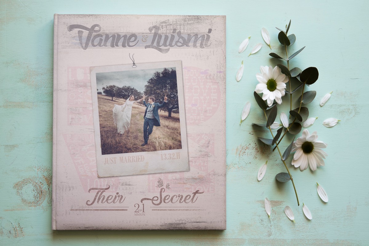 Bonito bodegón sobre fondo azul de un álbum de boda digital personalizado, de diseño exclusivo, diferente y único. Reportaje de la boda de Luismi y Vanne