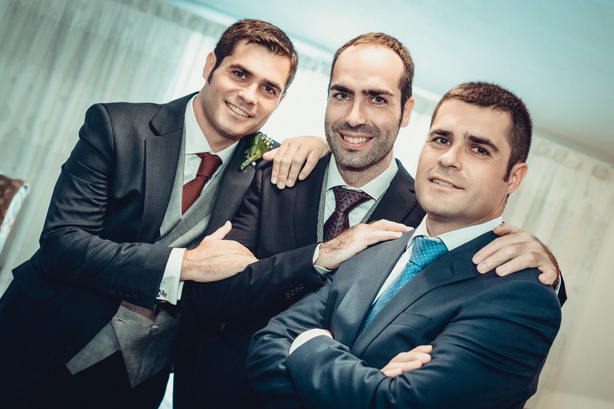 fotografía de grupo del novio con sus dos hermanos en una pose informal