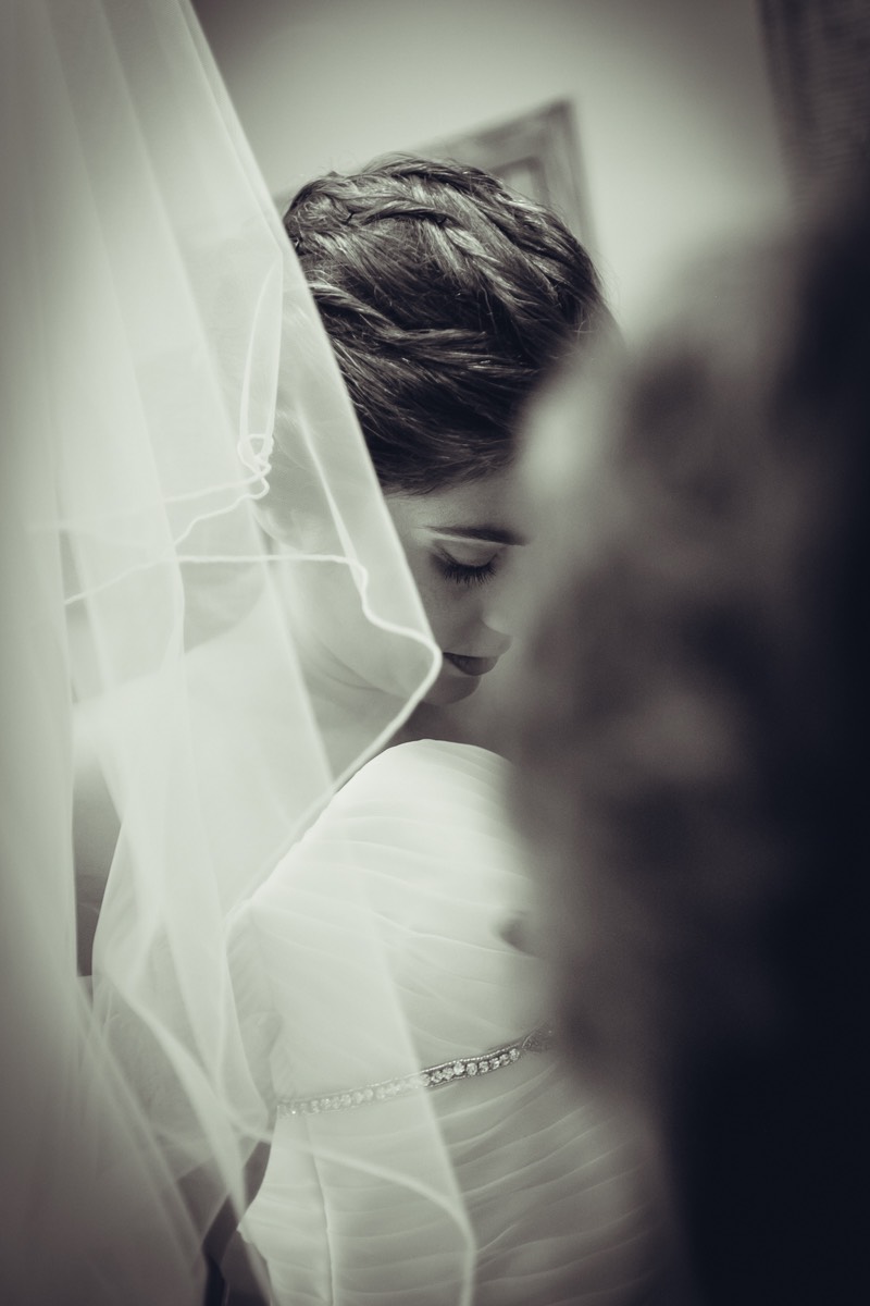Novia sonriente preparando su vestido de boda en camisón
