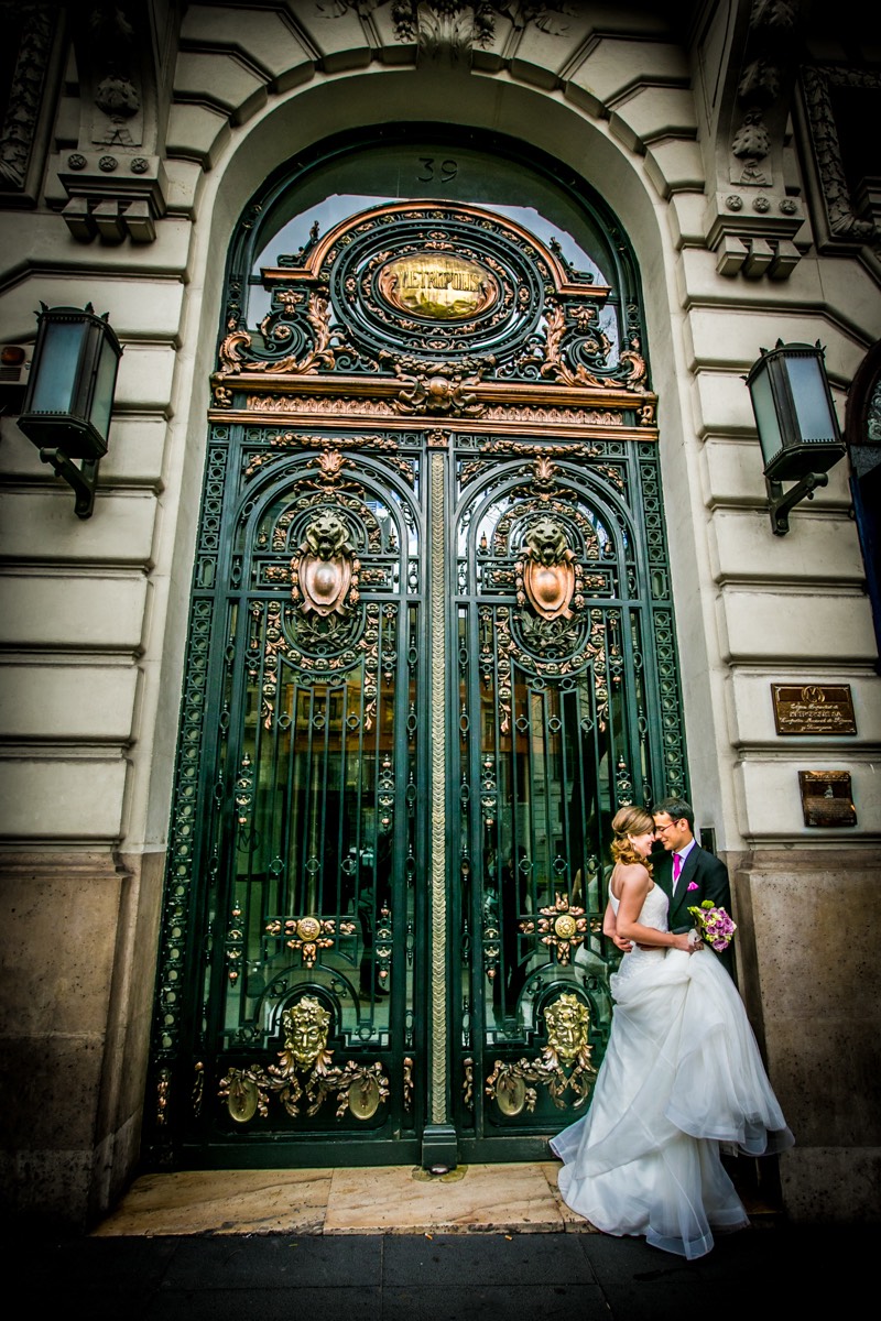 Pareja de novios beándose el día de su boda en una puerta de la calle Alcalá de Madrid