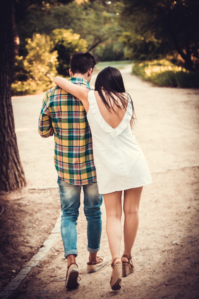 Fotografía de una pareja de novios de espaldas andando. Foto perteneciente a un reportaje de preboda realizado en el parque Quinta de los Molinos en Madrid por bodas con fotos fotógrafos de Bodas